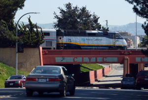 An Amtrak train passes over cars traveling on Macdonald Ave. as it departs the station in Richmond, Calif. on Monday, March 24, 2014. The tracks that carry
